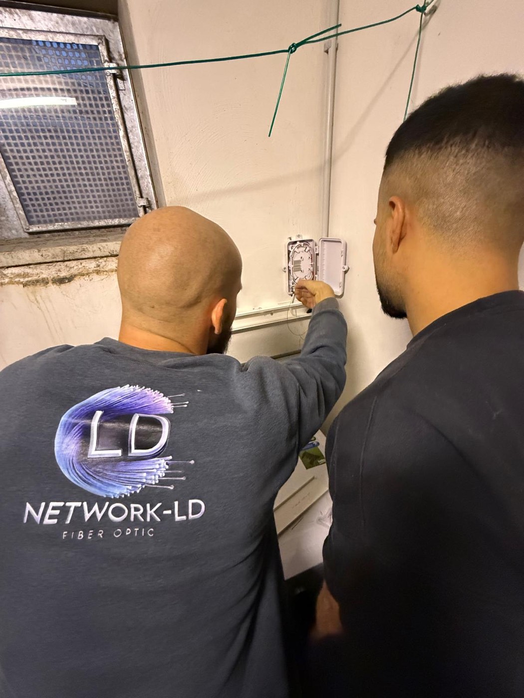 Team der Network-LD GmbH bei der Glasfaser-Installation an einem Abschlusspunkt im Gebäude